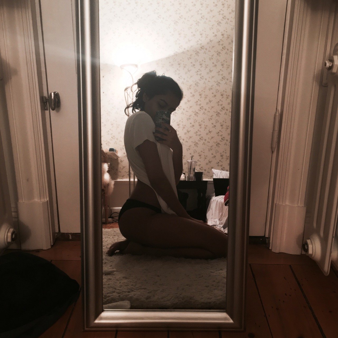 Брюнетка позирует перед зеркалом в гардеробной комнате и фотографирует обнаженное тело в разных позах