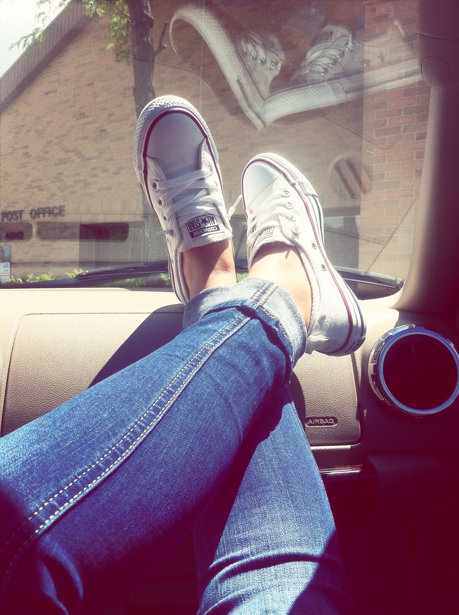 Ноги девушки в машине в кроссовках