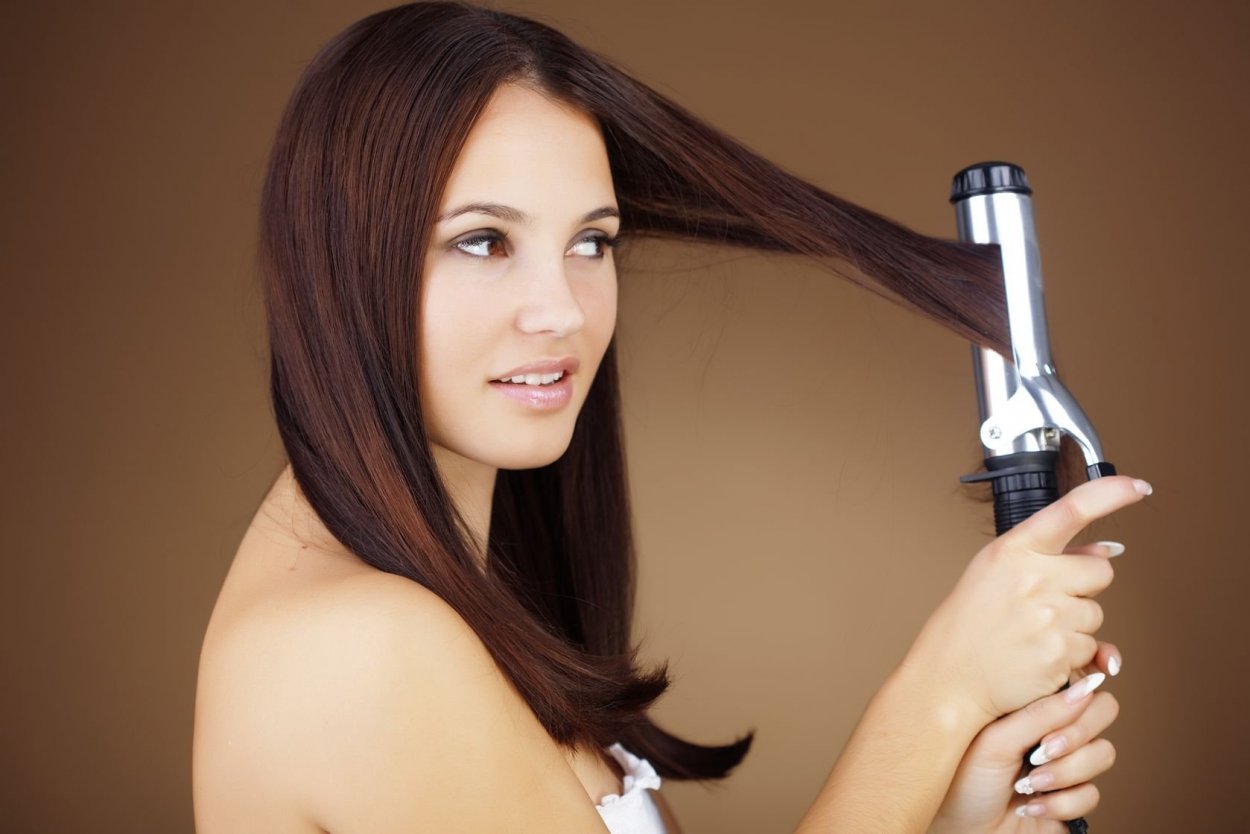 Девушка с щипцами для волос