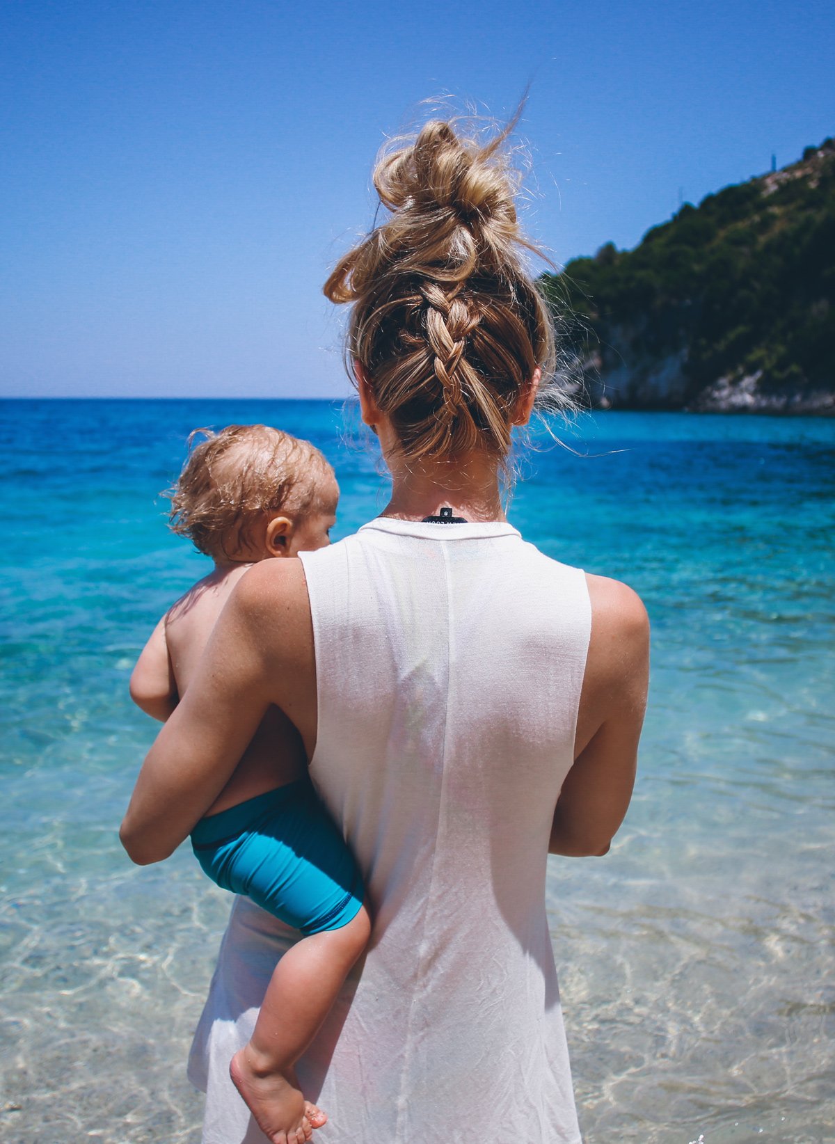 Фото блондинки с ребенком на руках со спины