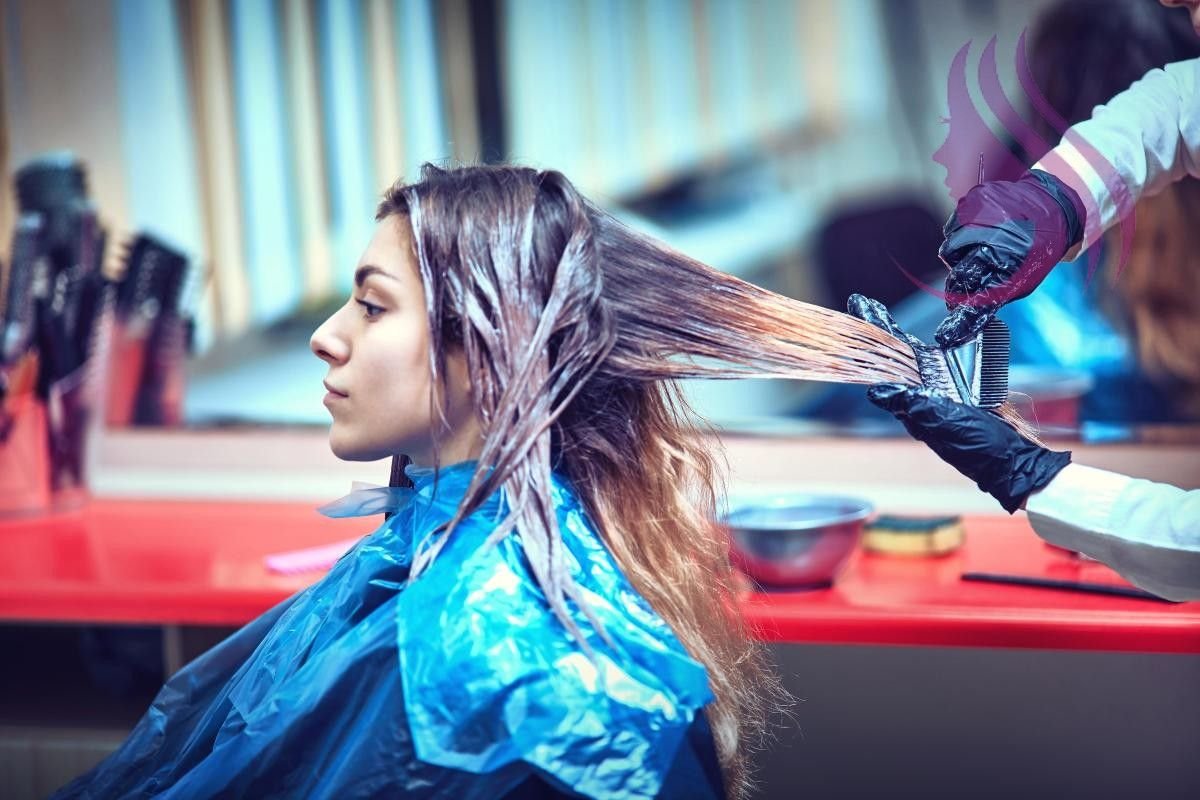 Девушка красит волосы в парикмахерской