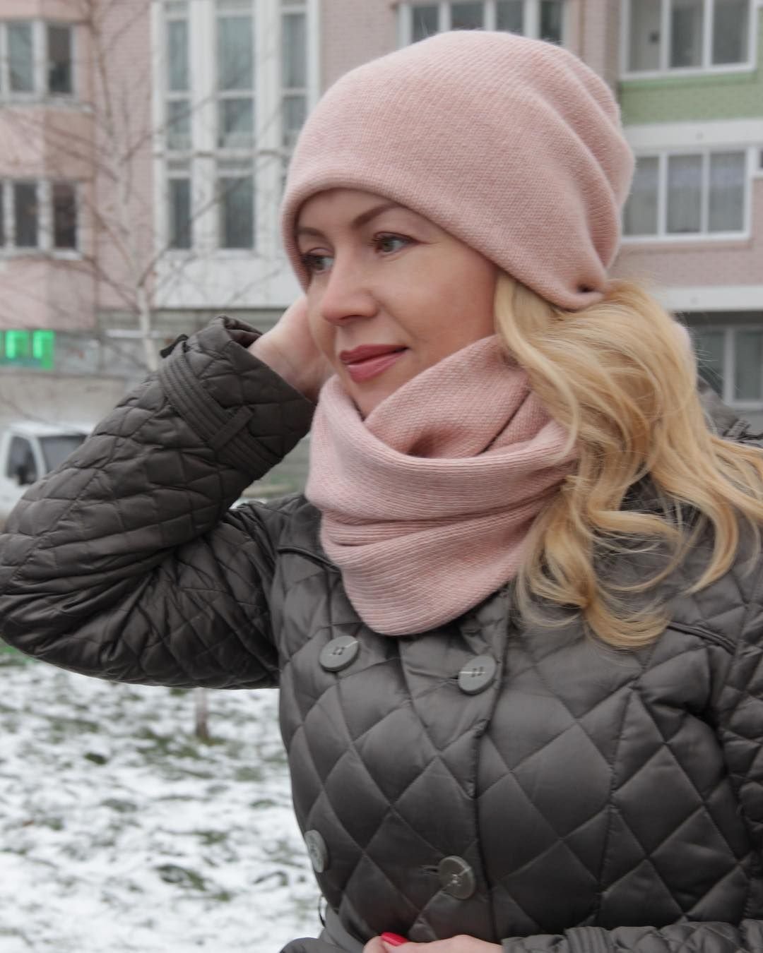 Черный пуховик и розовая шапка